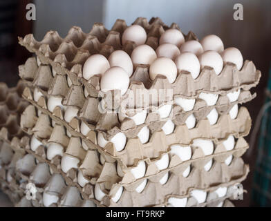 6 couches d'oeufs pour la vente. Une pile d'appartements de blanc de poulet oeufs à vendre dans un marché local. Beaucoup de la couche supérieure sont partis Banque D'Images