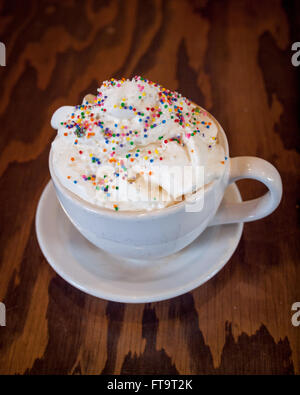 Un gâteau chaud avec latté et saupoudre de couleur crème fouettée de d'établir par Tish Café à Saskatoon, Saskatchewan, Canada. Banque D'Images