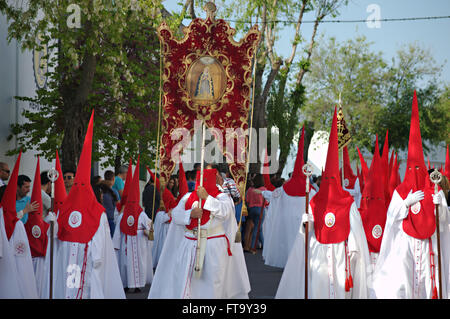 Un pénitents catholiques appartenant à un Cofradias, confréries religieuses ou traditionnelles d'usure avant-hoods lors d'une procession de Pâques dans le cadre des célébrations de la semaine sainte à Séville, Espagne. Banque D'Images