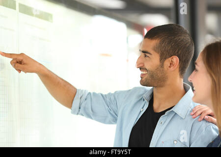 L'homme arabe et son amie dans une annexe de la gare routière ou pointant avec sa main Banque D'Images