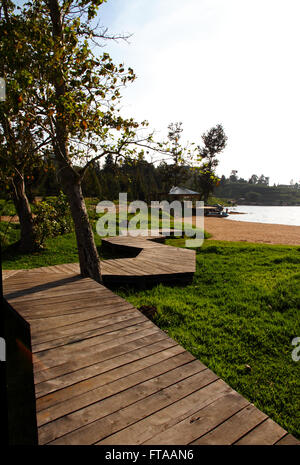 Une passerelle en bois sinueux menant à une herbe luxuriante empty beach Banque D'Images