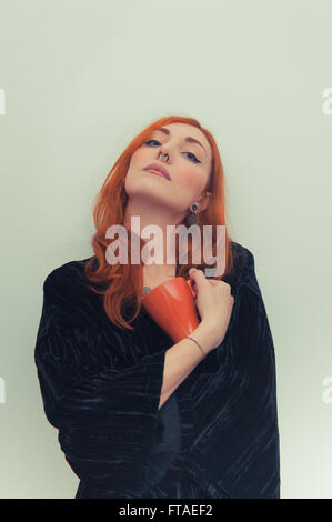 Jeune femme rousse avec orange mug vintage portrait effet de couleur permanent Banque D'Images