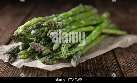 Asperges vertes (fraîches) récoltés sur une vieille table en bois (selective focus) Banque D'Images