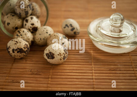 Oeufs de caille dans un bol en verre décoratif sur la table Banque D'Images