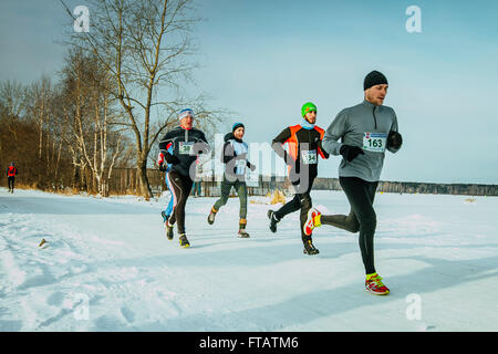 Ekaterinbourg, Russie - le 14 novembre 2015 : les athlètes et les hommes du groupe de fille courir le long de la rive Lac recouvert de neige pendant marathon Banque D'Images