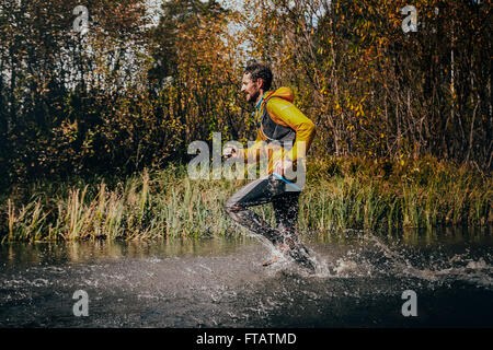 Beloretsk, Russie - le 26 septembre 2015 : Traversée d'une rivière de montagne runner, autour de lui les projections d'eau lors de marathon Banque D'Images