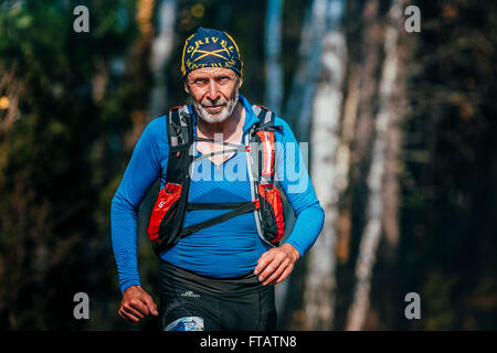 Beloretsk, Russie - le 26 septembre 2015 : beautiful smiling senior man ans courant à travers les bois pendant la montagne marathon Banque D'Images