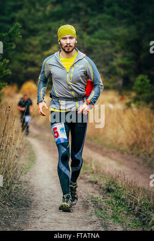 Beloretsk, Russie - le 26 septembre 2015 : young male runner traversant la route forestière pendant 'big mountain marathon Iremel" Banque D'Images