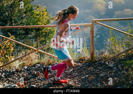 Girl runner est en marche sur un sentier de montagne. en fond de vallée de montagne en montagne marathon Banque D'Images