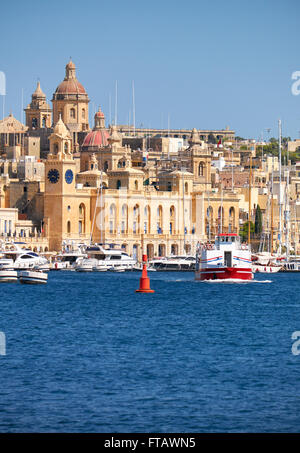 La vue des bâtiments historiques de Birgu à travers l'arsenal creek avec Cruises navire passant le long de la côte, à Malte. Banque D'Images