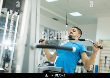Vue de la formation de jeune homme dans la salle de sport Banque D'Images