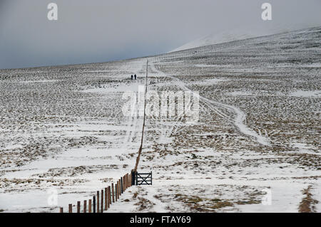 Deux Fellwalkers marchant à côté d'une clôture près de petit homme Siddaw Cumbria en hiver. UK. Banque D'Images