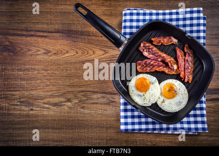 Jambon et oeuf. Bacon et des oeufs. Œuf salé et saupoudré de poivre noir. Petit-déjeuner anglais. Lard grillé, deux œufs dans le moule Banque D'Images