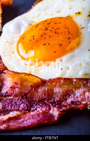 Jambon et oeuf. Bacon et des oeufs. Œuf salé et saupoudré de poivre noir. Petit-déjeuner anglais. Banque D'Images