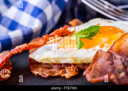 Jambon et oeuf. Bacon et des oeufs. Œuf salé et saupoudré de poivre noir. Petit-déjeuner anglais. Banque D'Images