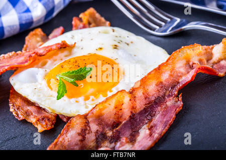 Jambon et oeuf. Bacon et des oeufs. Œuf salé et saupoudré de poivre noir. Petit-déjeuner anglais. Banque D'Images