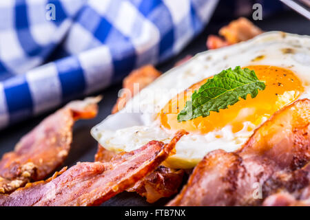 Jambon et oeuf. Bacon et des oeufs. Œuf salé et saupoudré de poivre noir. Petit-déjeuner anglais. Banque D'Images