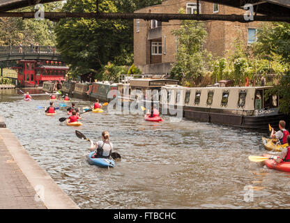 Une vue panoramique sur le Regents Canal navigable occupé à Londres montrant péniches amarrées et les canoteurs Banque D'Images