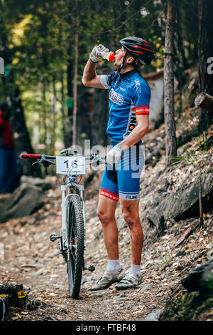Sludorudnik, Russie - le 13 septembre 2015 : racer biker in woods sports boissons potable en bouteille pendant l'Blagikh Racing Cup Banque D'Images