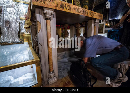 File d'attente des pèlerins de toucher le rocher du calvaire dans la chapelle de la Crucifixion dans l'Église Saint-sépulcre, vieille ville de Jérusalem, Israël Banque D'Images