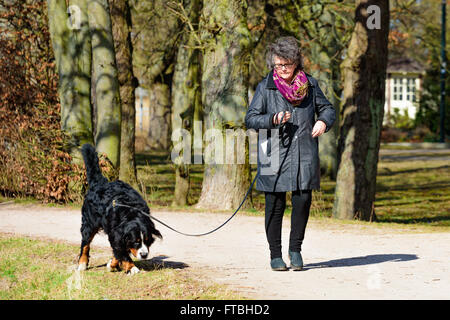 Kristianstad, Suède - 20 mars 2016 : maître-chien et son chien de prendre une promenade dans le parc. Un jour de printemps ensoleillé avec du vrai Banque D'Images