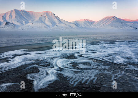 Coucher du soleil à rives gelés Sjøskrenten Hiorthfjellet avec vue sur la plage, Longyearbyen, Spitsbergen, Svalbard. Banque D'Images