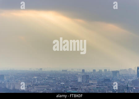 Vue aérienne de la ville de Londres avec des rayons de lumière perçant à travers les nuages pour atteindre les bâtiments. Banque D'Images