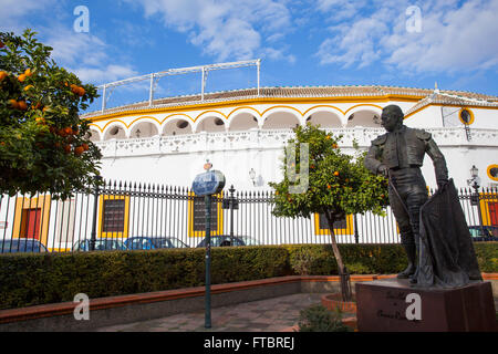 Curro Romero statue avec ''Plaza de toros de la Real Maestranza de Caballería de Séville'' à l'arrière-plan. L'Andalousie, espagne. Banque D'Images