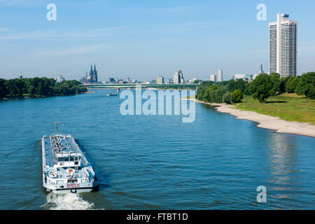 Köln, Deutschland, Blick von der Mühlheimer Brücke über euin Frachtschiff auf das linke Rheinufer und zum Colonia Haus. Banque D'Images