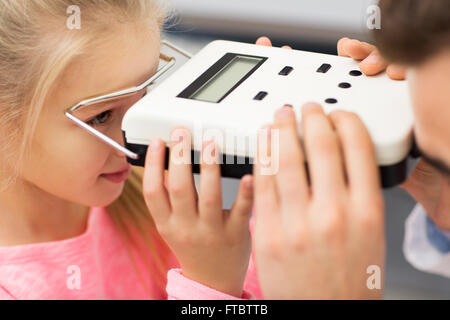 Opticien avec pupillometer et fille à eye clinic Banque D'Images