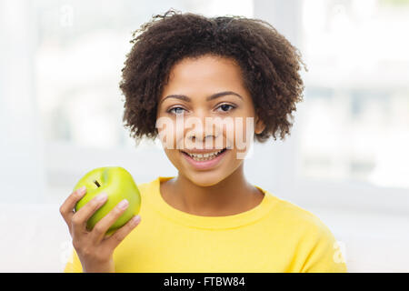 Happy african american woman with green apple Banque D'Images