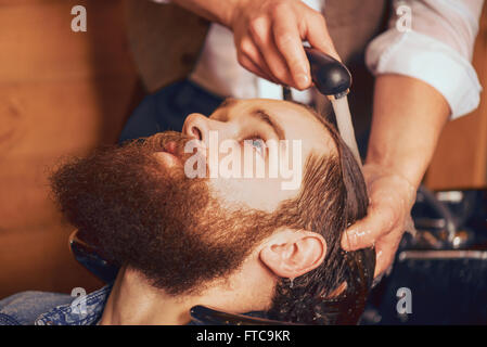 Coiffure lave tête d'homme barbu Banque D'Images