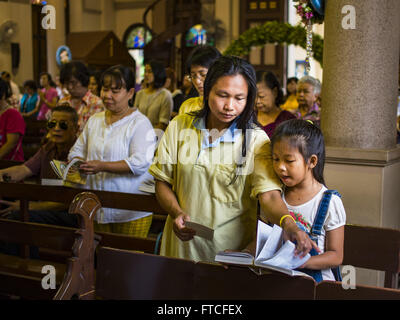 Bangkok, Bangkok, Thaïlande. Mar 27, 2016. Une femme ouvre sa fille hymnal durant Pâques services à l'église de Santa Cruz à Bangkok. Santa Cruz est l'une des premières églises catholiques établi à Bangkok. Il a été construit à la fin des années 1700 par des soldats portugais allié au Roi Taksin le grand dans ses batailles contre les Birmans qui ont envahi la Thaïlande (Siam) ensuite. Il y a environ 300 000 catholiques en Thaïlande, dans 10 diocèses avec 436 paroisses. Pâques marque la résurrection de Jésus après sa crucifixion et est célébrée dans les communautés chrétiennes à travers le monde. (Crédit Image : © Jack1977 Banque D'Images