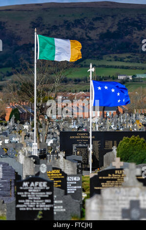 Belfast, Irlande du Nord. 27 Mar 2016 - Une Centenaire 1916/2016, drapeau tricolore irlandais et le ciel étoilé au-dessus du volant de la charrue d'Antrim County Memorial à Milltown Cemetery, avec une grande bannière d'être déployé sur le côté de la Montagne Noire. Crédit : Stephen Barnes/Alamy Live News Banque D'Images