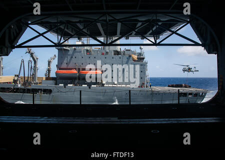 Océan Indien (20 juillet 2015) Un Sea Hawk MH-60S de la "matraques" d'hélicoptères de combat de la mer transporte 21 Escadron palettes de l'USNS (Patuexent T-AO 201) à l'assaut amphibie USS Essex (DG 2) au cours d'un ravitaillement en mer. Les Marines américains avec la 15e unité expéditionnaire de marines et de marins avec le groupe amphibie Essex travaillent ensemble afin de décharger la poste, de l'équipement, et de la nourriture à distribuer dans tout le navire. Éléments de la 15e MEU, basé à Camp Pendleton, en Californie, et embarquée à bord de l'Essex, mènent des opérations navales dans la 6ème zone d'opérations de la flotte à l'al. Banque D'Images