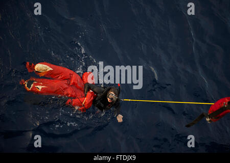 151217-N-FP878-149 MER MÉDITERRANÉE (déc. 17, 2015) 1ère classe Controlman feu Mike, Barbatelli de Ft. Pierce, Floride, donne le signal d'élever lui-même et la simulation d'une victime sur le gaillard au cours d'un scénario de formation d'un homme à la mer à bord de l'USS Carney (DDG 64) Décembre 17, 2015. Carney, une classe Arleigh Burke destroyer lance-missiles déployés avant, à Rota, Espagne, effectue une patrouille de routine dans la 6ème zone d'opérations de la flotte à l'appui des intérêts de sécurité nationale des États-Unis en Europe. (U.S. Photo par marine Spécialiste de la communication de masse 1re classe Theron J. Godbold/libérés) Banque D'Images