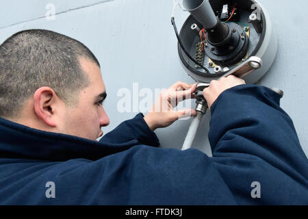 Communications intérieures électricien de 3e classe Jorge Flores remplace un haut-parleur à bord de l'USS Carney, un destroyer à missiles guidés de classe Arleigh Burke, lors de son déploiement en mer Méditerranée pour soutenir les intérêts de sécurité américains. Banque D'Images