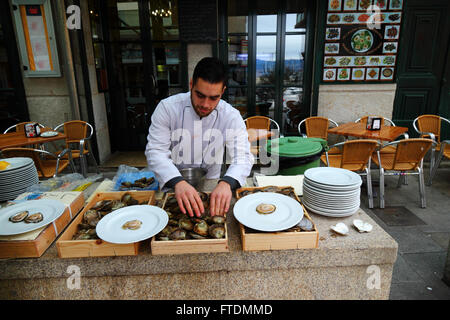 Les huîtres tri par taille l'homme à l'extérieur restaurant de fruits de mer, Vigo, Galice, Espagne Banque D'Images