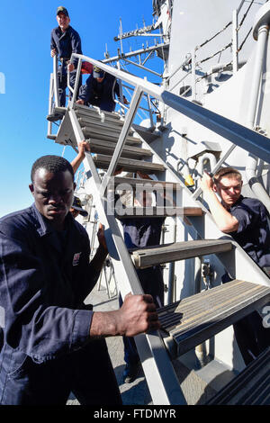 Les marins à bord de l’USS *Carney* (DDG 64), un destroyer à missiles guidés de classe Arleigh Burke, sécurisent une échelle lors de patrouilles de routine en mer Méditerranée le 1er mars 2016. Le navire est stationné à Rota, en Espagne, soutenant les intérêts de sécurité nationale des États-Unis. Banque D'Images