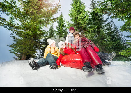 Happy kids équitation en bas de la colline sur red ice-boat Banque D'Images