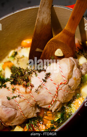 La viande d'agneau avec la jambe en entier dans un pot avec des légumes , thym et romarin Banque D'Images