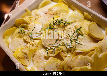 Les pommes de terre avec la crème et le romarin dans une casserole Banque D'Images