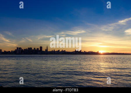 Horizon de San Francisco au coucher du soleil avec une silhouette de gratte-ciel et le Bay Bridge, avec des nuages Banque D'Images Horizon de San Francisco au coucher du soleil avec une silhouette de gratte-ciel et le Bay Bridge, avec des nuages Banque D'Images