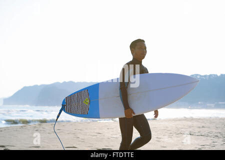 Surfeur japonais marche sur la plage Banque D'Images