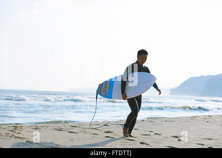 Surfeur japonais marche sur la plage Banque D'Images