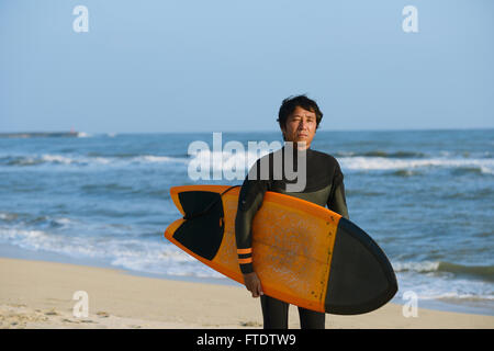 Portrait surfeur japonais sur la plage Banque D'Images