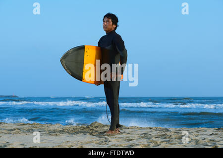 Portrait surfeur japonais sur la plage Banque D'Images