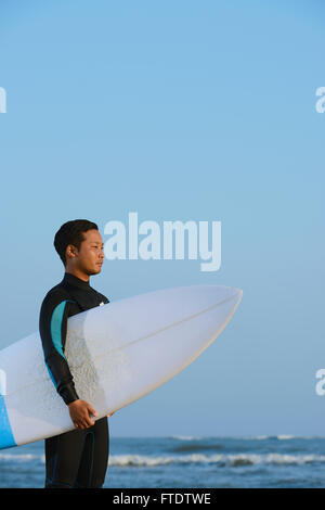 Portrait surfeur japonais sur la plage Banque D'Images
