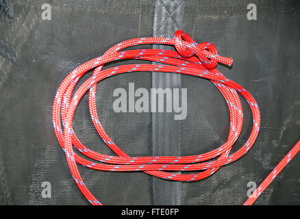 Close up figure huit noeud fait dans une corde pour les marins en acrylique rouge Banque D'Images
