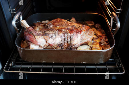 Le dimanche midi d'épaule d'agneau rôti lentement avec des pommes de terre la cuisson dans un four électrique Banque D'Images